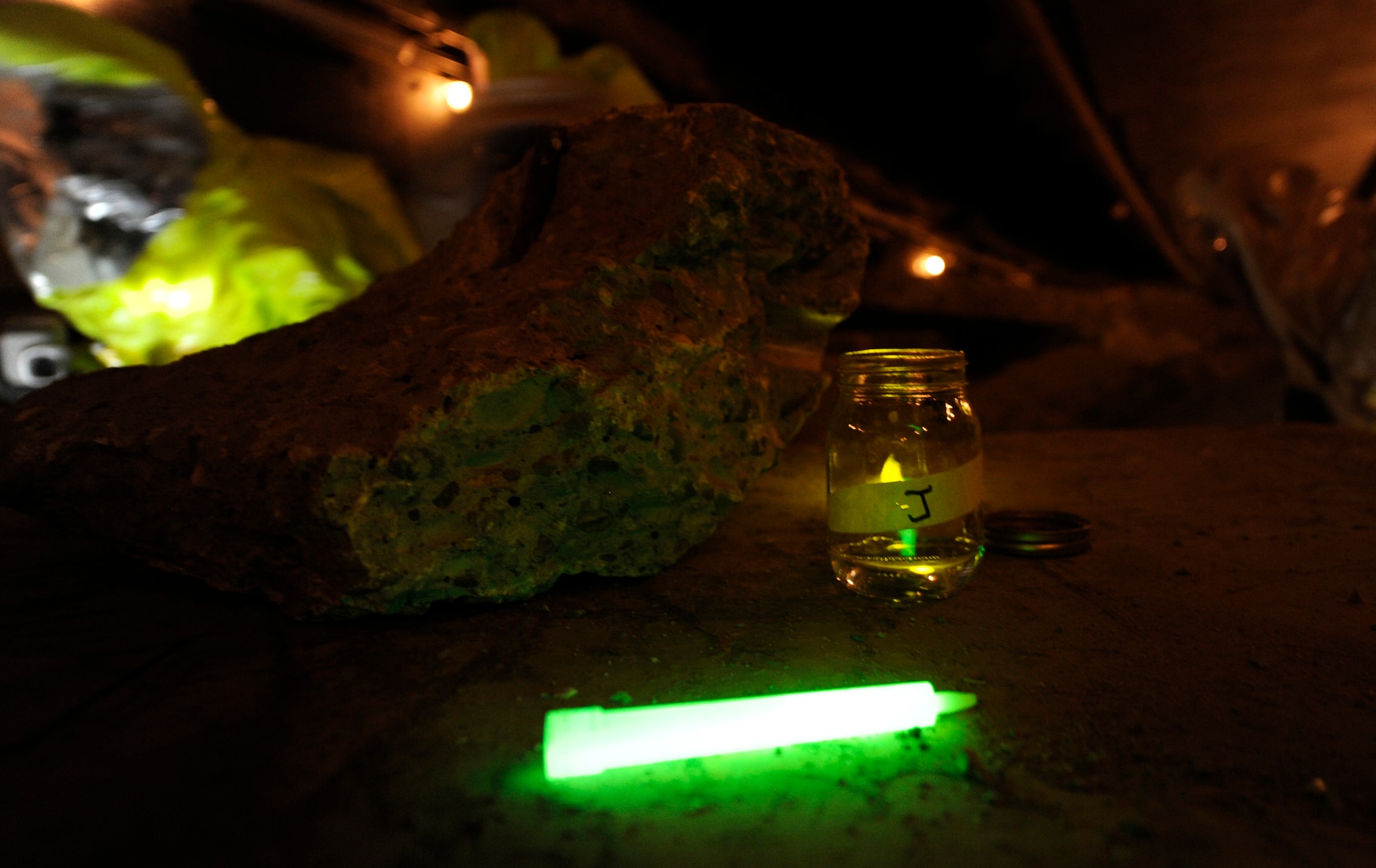 Civil Engineering Airmen use glow sticks to mark jars filled with active chemical agents during a Black Flag training exercise at the Center for National Response in W.Va., March 27, 2014. The student Airmen must track their findings for the next team to follow and test what types of agents they are working with. (U.S. Air Force Photo/ Airman 1st Class Nesha Humes)