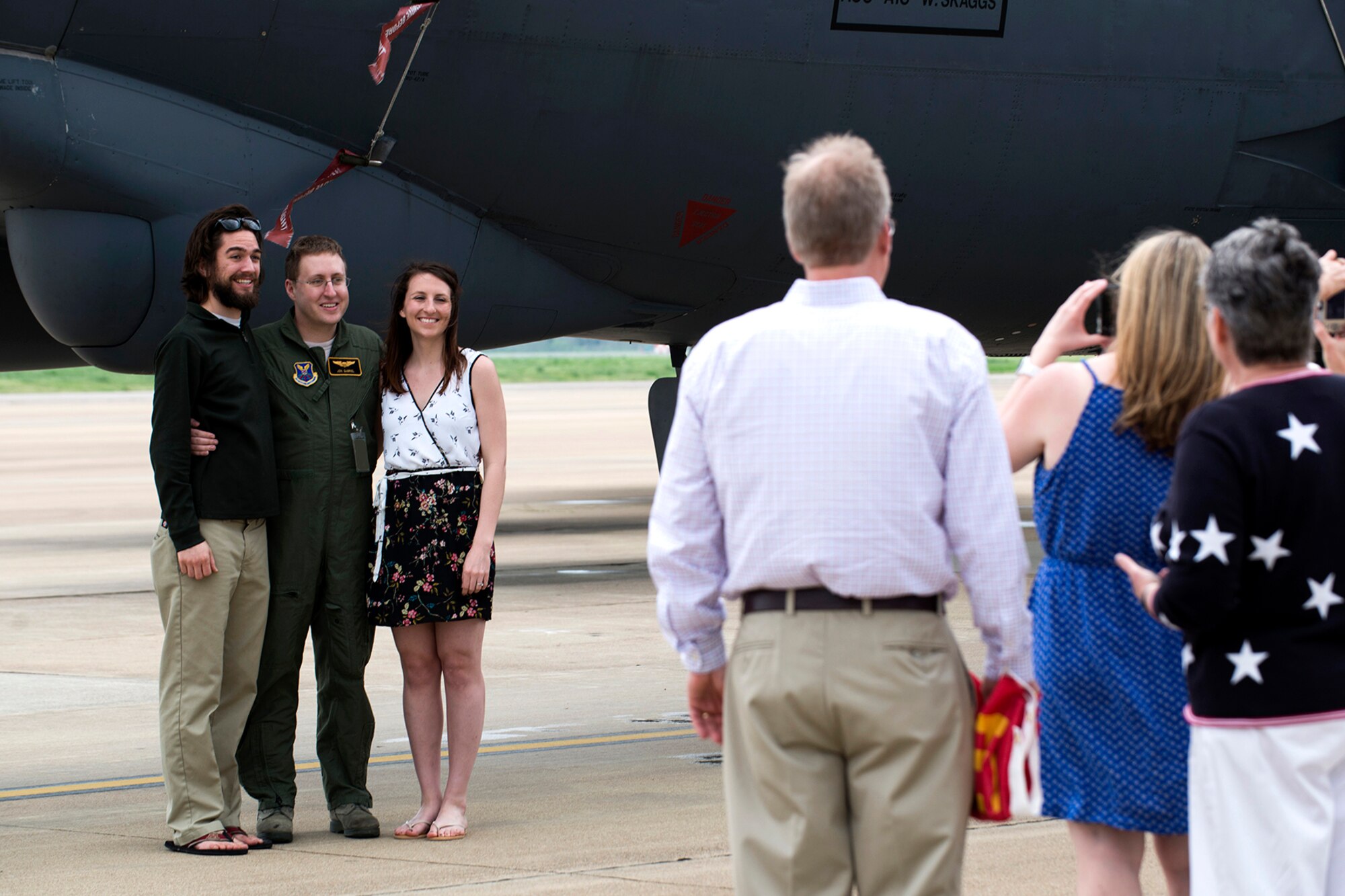 U.S. Air Force 1st Lt. Jonathan Gabriel takes a photo with family following his graduation from the B-52 Formal Training Unit, April 2, 2014, Barksdale Air Force Base, La. After the ceremony, graduates were able to give a tour on the aircraft they were trained to fly and operate. (U.S. Air Force photo by Master Sgt. Greg Steele/Released)