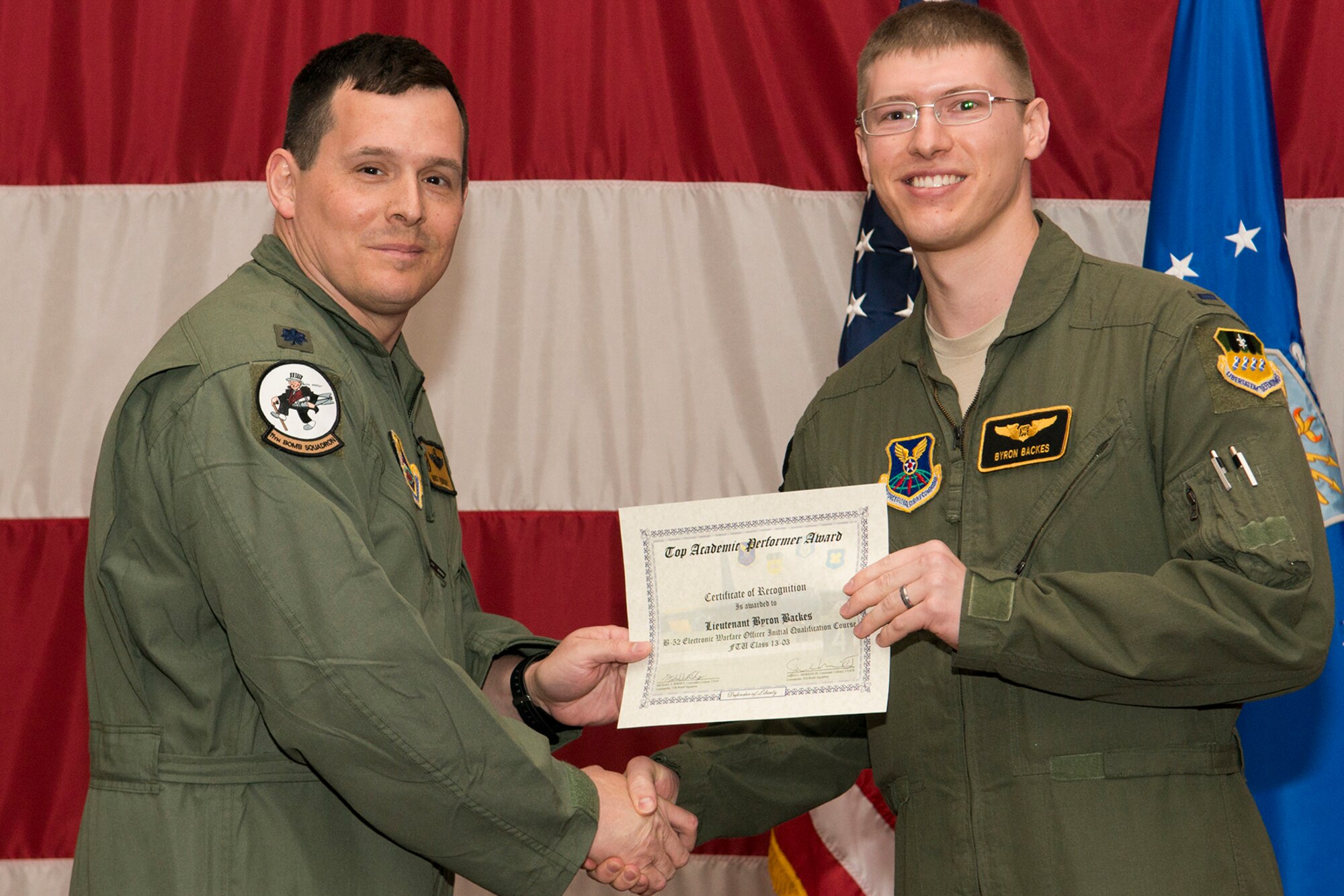 U.S. Air Force Lt. Col. Michael Rimsky, 11th Bomb Squadron commander, presents a Certificate of Recognition to 1st Lt. Byron Backes during a B-52 Formal Training Unit graduation ceremony, April 2, 2014, Barksdale Air Force Base, La. Backes was recognized for graduating as the top academic performer in the B-52 Electronic Warfare Officer Initial Qualification Course. (U.S. Air Force photo by Master Sgt. Greg Steele/Released)