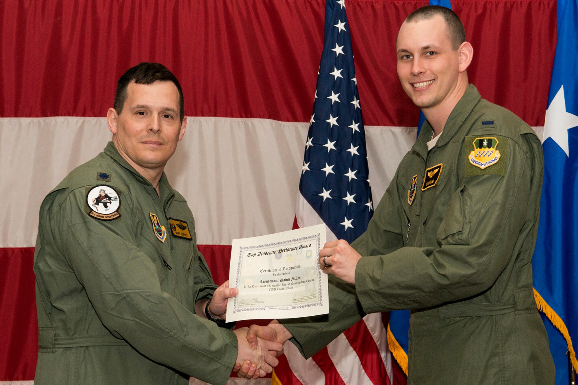 U.S. Air Force Lt. Col. Michael Rimsky, 11th Bomb Squadron commander, presents a Certificate of Recognition to 1st Lt. David Miller during a B-52 Formal Training Unit graduation ceremony, April 2, 2014, Barksdale Air Force Base, La. Miller was recognized for graduating as the top academic performer in the B-52 Dual Seat Navigator Initial Qualification Course. (U.S. Air Force photo by Master Sgt. Greg Steele/Released)