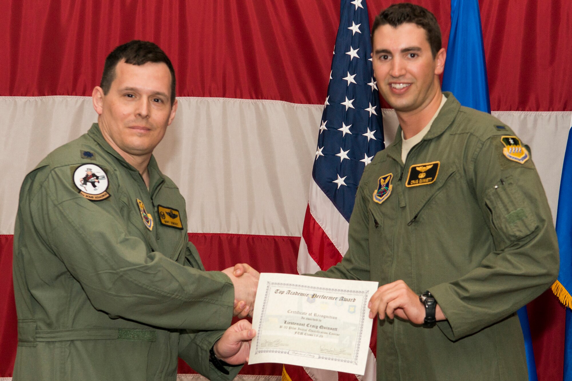 U.S. Air Force Lt. Col. Michael Rimsky, 11th Bomb Squadron commander, presents a Certificate of Recognition to 1st Lt. Craig Quinnett during a B-52 Formal Training Unit graduation ceremony, April 2, 2014, Barksdale Air Force Base, La. Quinnett was recognized for graduating as the top academic performer in the B-52 Pilot Initial Qualification Course. (U.S. Air Force photo by Master Sgt. Greg Steele/Released)