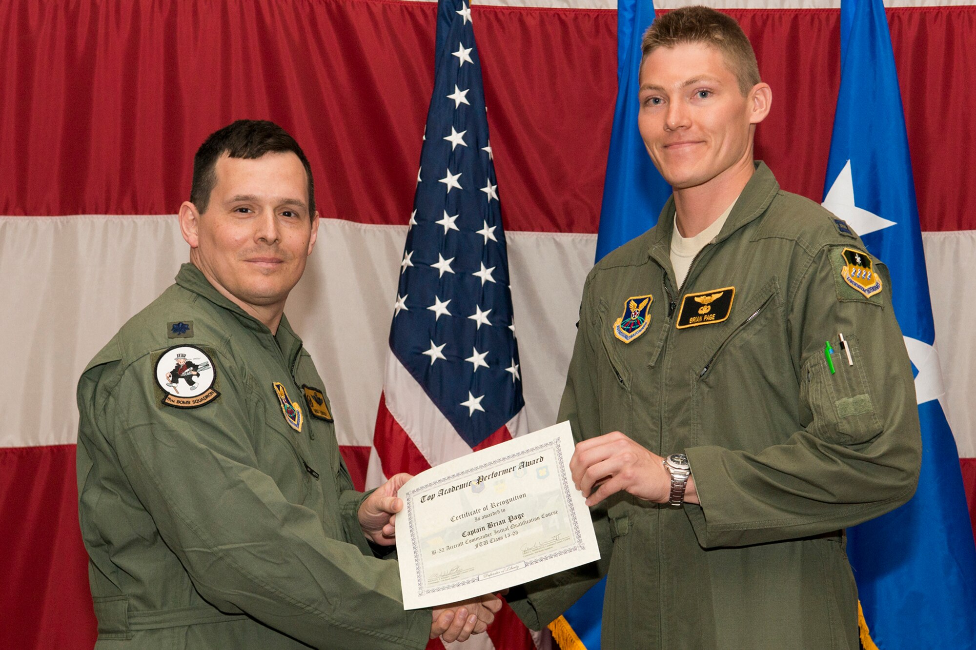U.S. Air Force Lt. Col. Michael Rimsky, 11th Bomb Squadron commander, presents a Certificate of Recognition to Capt. Brian Page during a B-52 Formal Training Unit graduation ceremony, April 2, 2014, Barksdale Air Force Base, La. Page was recognized for graduating as the top academic performer in the B-52 Aircraft Commander Initial Qualification Course. (U.S. Air Force photo by Master Sgt. Greg Steele/Released)