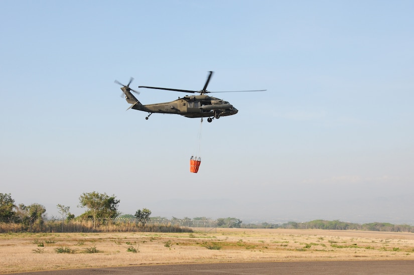 A U. S. Army UH-60 Blackhawk helicopter from the 1-228th Aviation Regiment takes off from Soto Cano Air Base, Honduras with a Bambi Bucket attached to fight a fire on a mountain ridge in Comayagua, Honduras.  The fire posed a threat to destroy homes and to cut off an access road to a local village.  Within one hour of receiving the call, the helicopters dumped about 6,180 gallons of water on the blaze to alleviate the danger.  (Photo by U. S. Air National Guard Capt. Steven Stubbs)