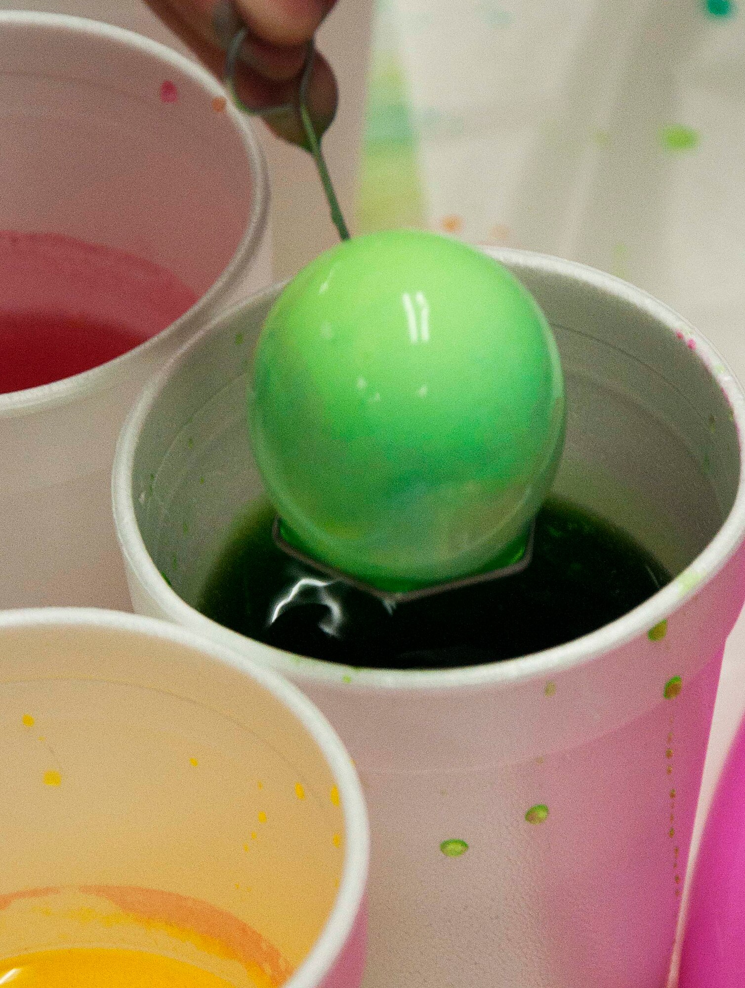 140402-F-GZ967-037 An egg is dipped into a cup of colored dye April 2 during the Easter Egg-stravaganza at the Arts and Crafts Center. Dying eggs was one of the many free activities offered for children to participate in – including a craft table and a photo opportunity with the Easter Bunny.  (U.S. Air Force photo by Airman 1st Class Brandon Valle)