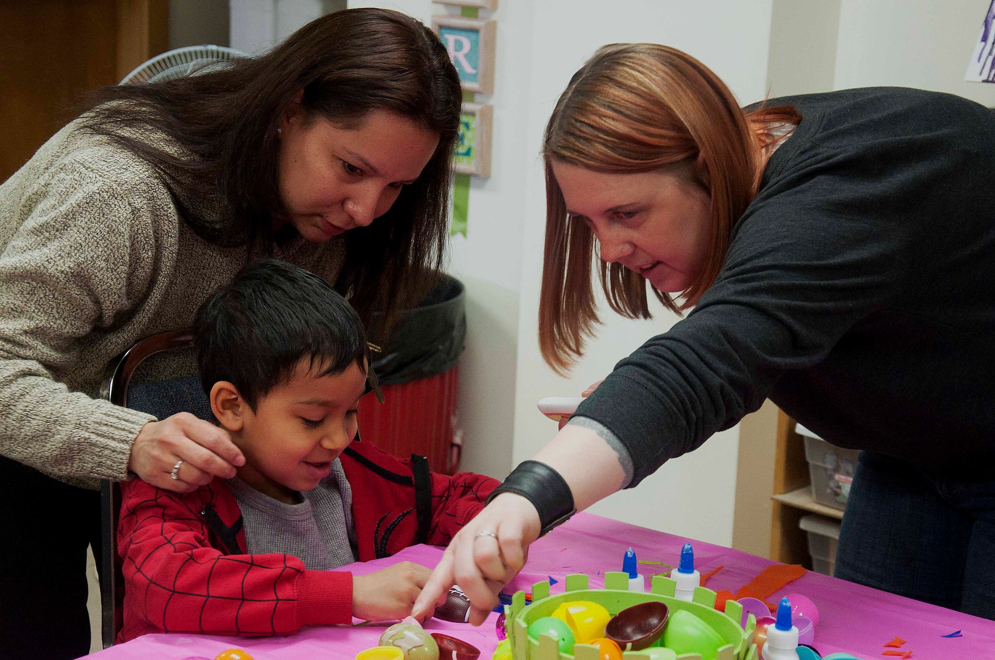 140402-F-GZ967-007 Monica Posion, Arts and Crafts Center embroidery specialist, helps Andrew Khan, 6, son of Master Sgt. Christine Khan, 90th Medical Operations Squadron, with an art project to turn plastic Easter eggs into a chicken April 2 during the Easter Egg-stravaganza at the Arts and Crafts Center. Children had the opportunity to use feathers, felt and goodly-eyes to design their own chicken. (U.S. Air Force photo by Airman 1st Class Brandon Valle)