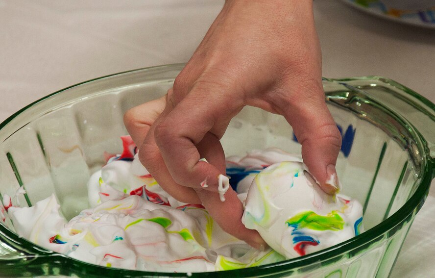 140402-F-GZ967-003 Amy Dent, Outdoor Recreations activities planner, shows children how to create colorful Easter eggs with shaving cream and food dye as one of the activities available during an Easter Egg-stravaganza April 2 in the Arts and Crafts Center. More than 500 eggs were available for children to color and dye however they wished. (U.S. Air Force photo by Airman 1st Class Brandon Valle)