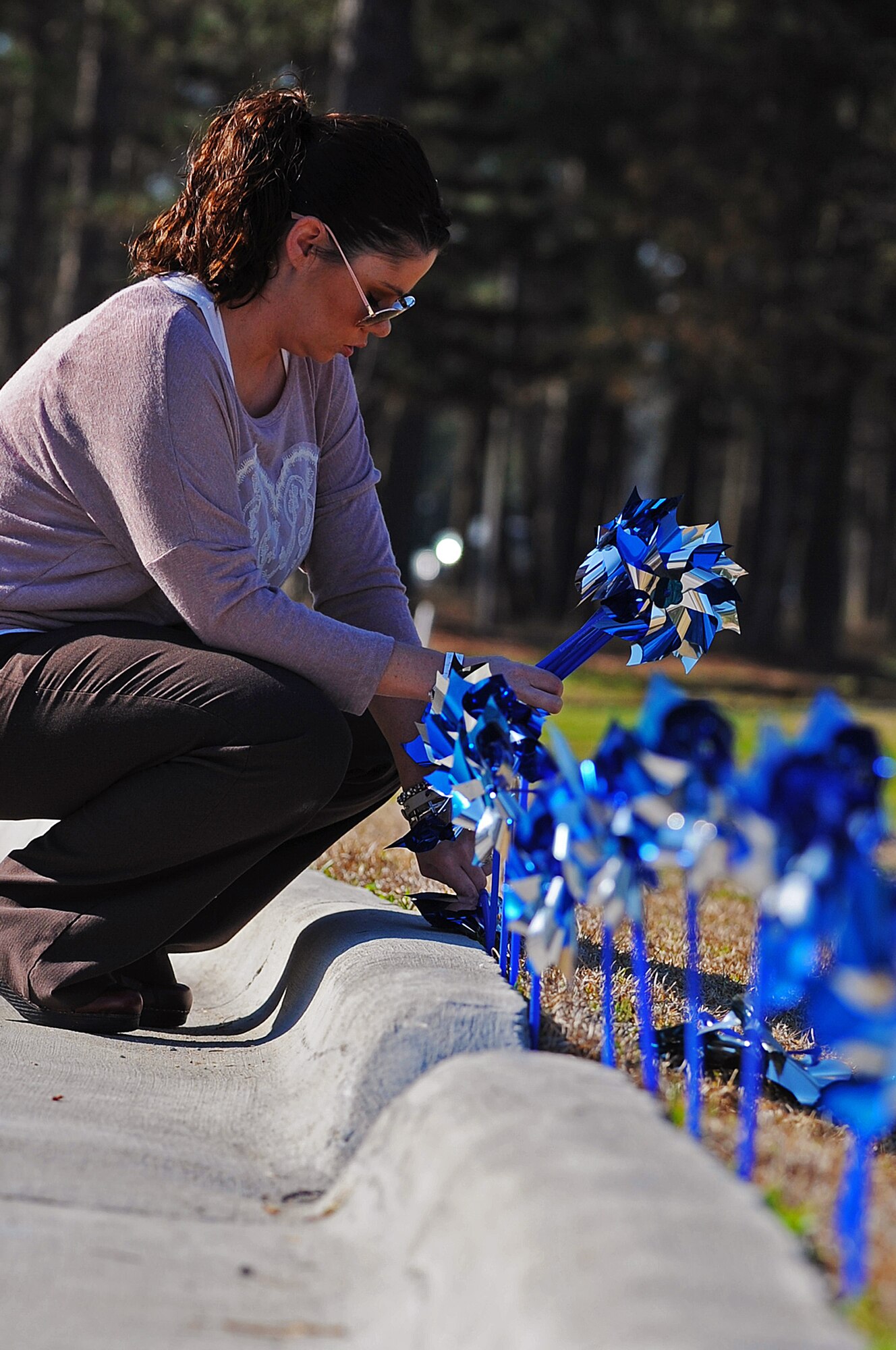 Jana Sabin, 4th Medical Operations Squadron domestic abuse victim advocate, places pinwheels for National Child Abuse Prevention Month near the main gate, April 2, 2014, at Seymour Johnson Air Force Base, N.C. Every April is recognized as Child Abuse Prevention Month by acknowledging the importance of families and communities working together to prevent child abuse and neglect. (U.S. Air Force photo/Tech. Sgt. Colette M. Graham)