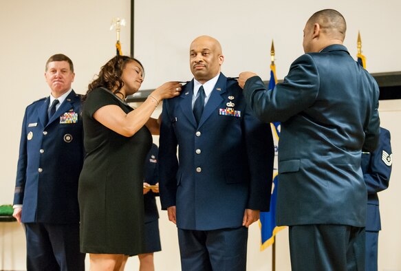 The wife and brother of Lt. Col. Charles Walker pin colonel’s rank to his uniform during a promotion ceremony at the Kentucky Air National Guard Base in Louisville, Ky., March 22, 2014. Walker, staff judge advocate for Joint Forces Headquarters Air Component, Kentucky National Guard, is the first African-American to be promoted to the rank of colonel in Kentucky Air Guard history. (U.S. Air National Guard photos by Staff Sgt. Vicky Spesard)