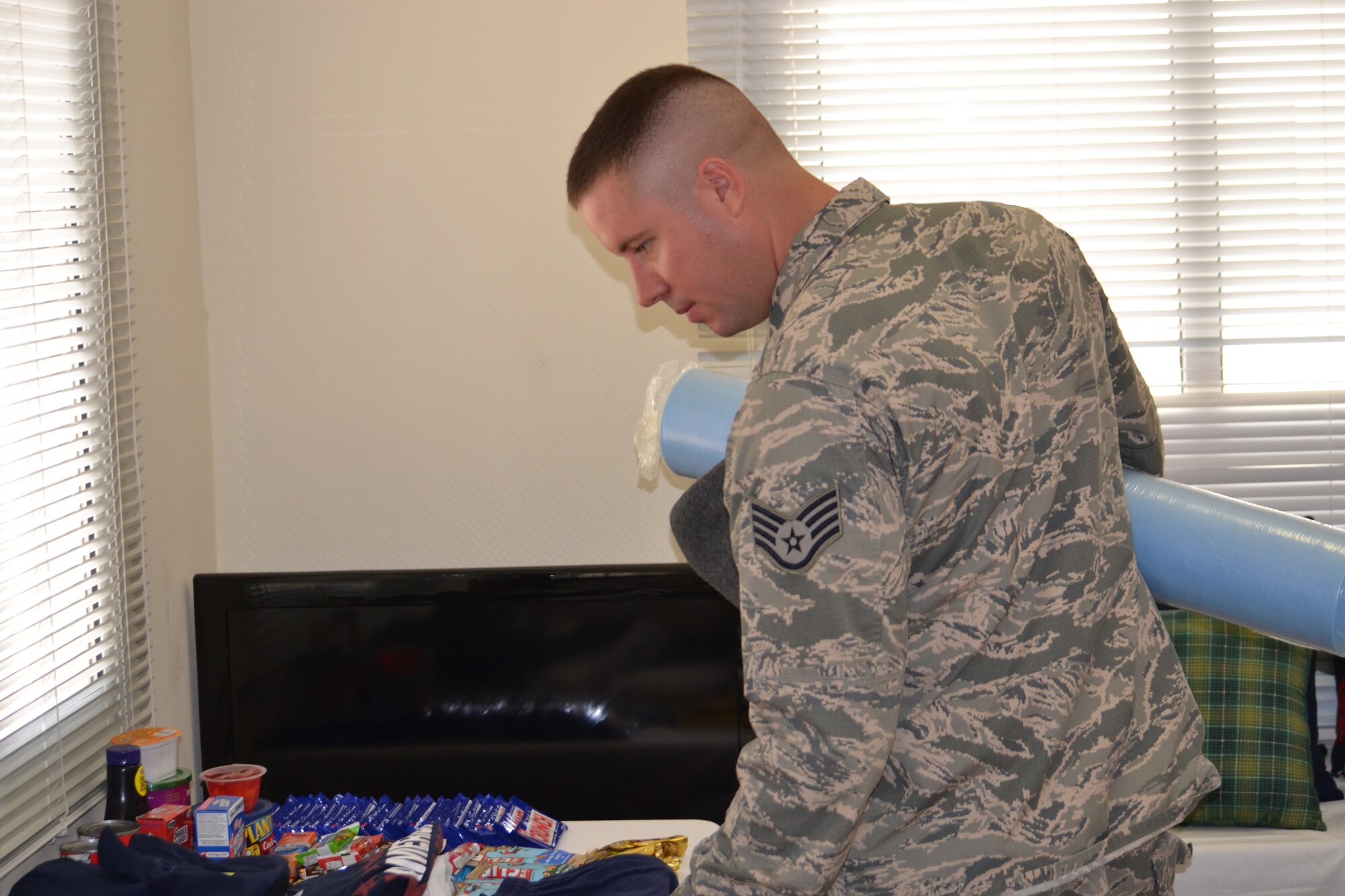 Staff Sgt. Travis Kyle, a public health technician assigned to the 379th Expeditionary Medical Operations Squadron, takes advantage of the free quality of life items provided by the Mental Health Clinic at Al Udeid Air Base, March 30, 2014.  Donations from the Landstuhl Hospital Care Project, amounting to about $20,000, were offered to service members through the mental health clinic’s open house in an effort to help boost morale and bring a face to the services offered by the MHC.   Kyle is a native of Lake Havasu City, Ariz., and deployed from Nellis Air Force Base, Ariz.   (U.S. Air Force Photo by Maj. Nicole David)
