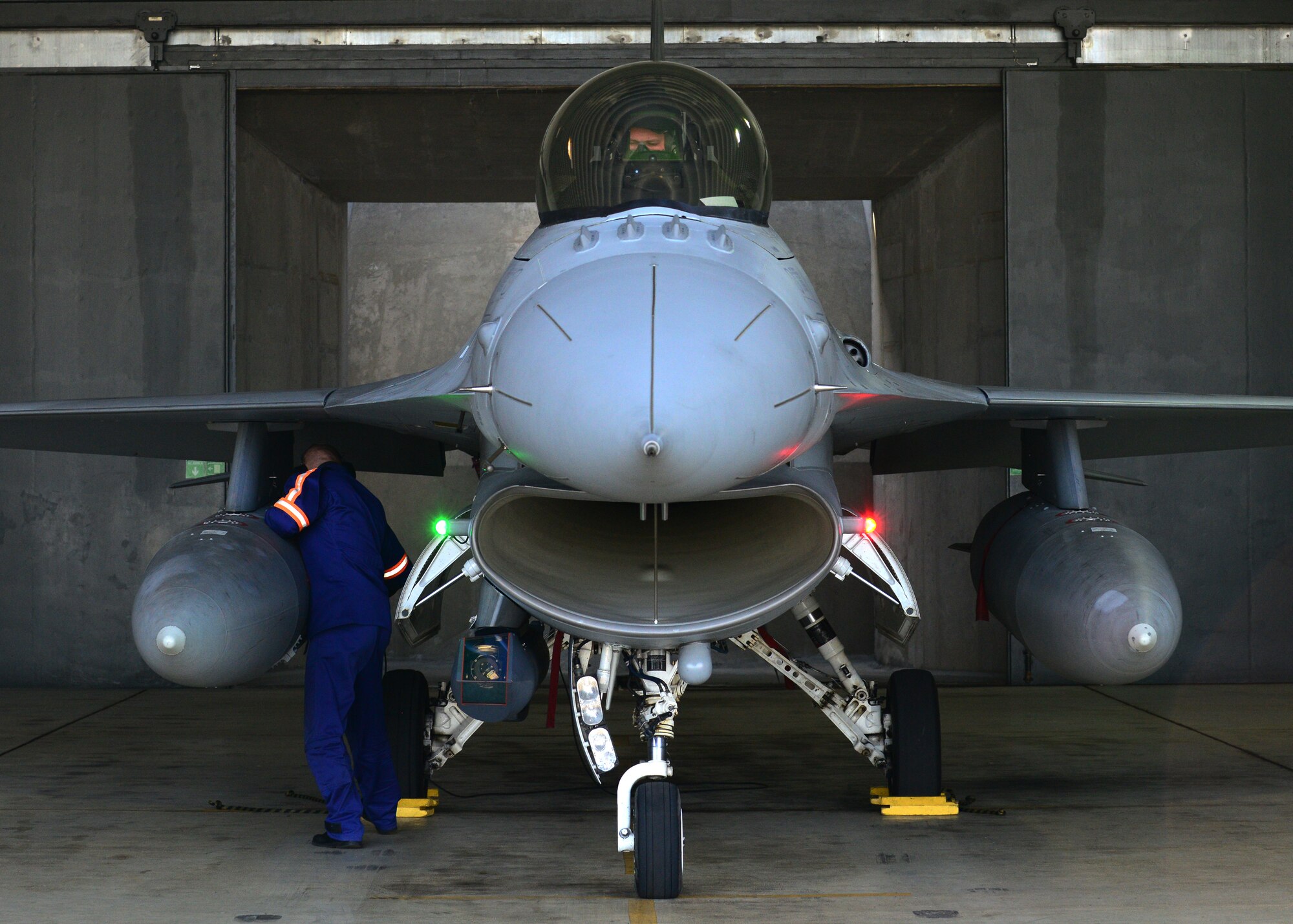 Polish air force Tech. Sgt. Piotr Kotlarek, 32nd Tactical Air Base crew chief, performs pre-flight checks on an F-16 Fighting Falcon aircraft before a training mission with U.S. aircraft and personnel, April 2, 2014, at Lask Air Base, Poland. More than 220 U.S. personnel have trained with Polish counterparts since March 13 to increase bilateral defense ties. Poland continues to build its partnership capacity with the U.S. as both nations' air forces integrate their capabilities through training sorties in a joint theater capacity. (U.S. Air Force photo/Airman 1st Class Ryan Conroy/ Released) 