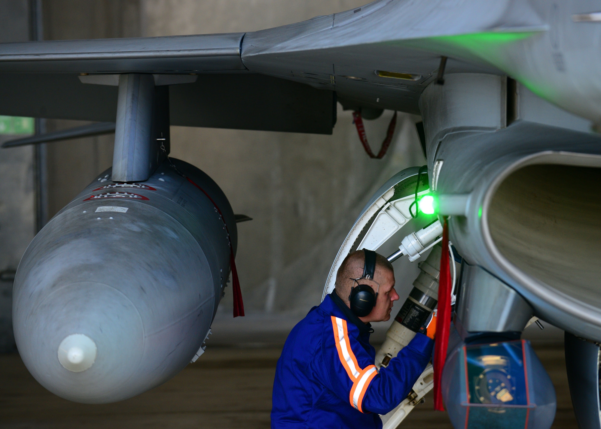 Polish air force Tech. Sgt. Piotr Kotlarek, 32nd Tactical Air Base crew chief, performs pre-flight checks on an F-16 Fighting Falcon fighter aircraft before a training mission with U.S. pilots, April 2, 2014, at Lask Air Base, Poland. These combined training exercises strengthen bilateral defense ties between the U.S. and Poland as NATO allies. The Polish air force implemented the use of F-16s to their inventory within the last ten years and is currently hosting twelve U.S. F-16s assigned to Aviano Air Base, Italy. (U.S. Air Force photo/Airman 1st Class Ryan Conroy/Released)