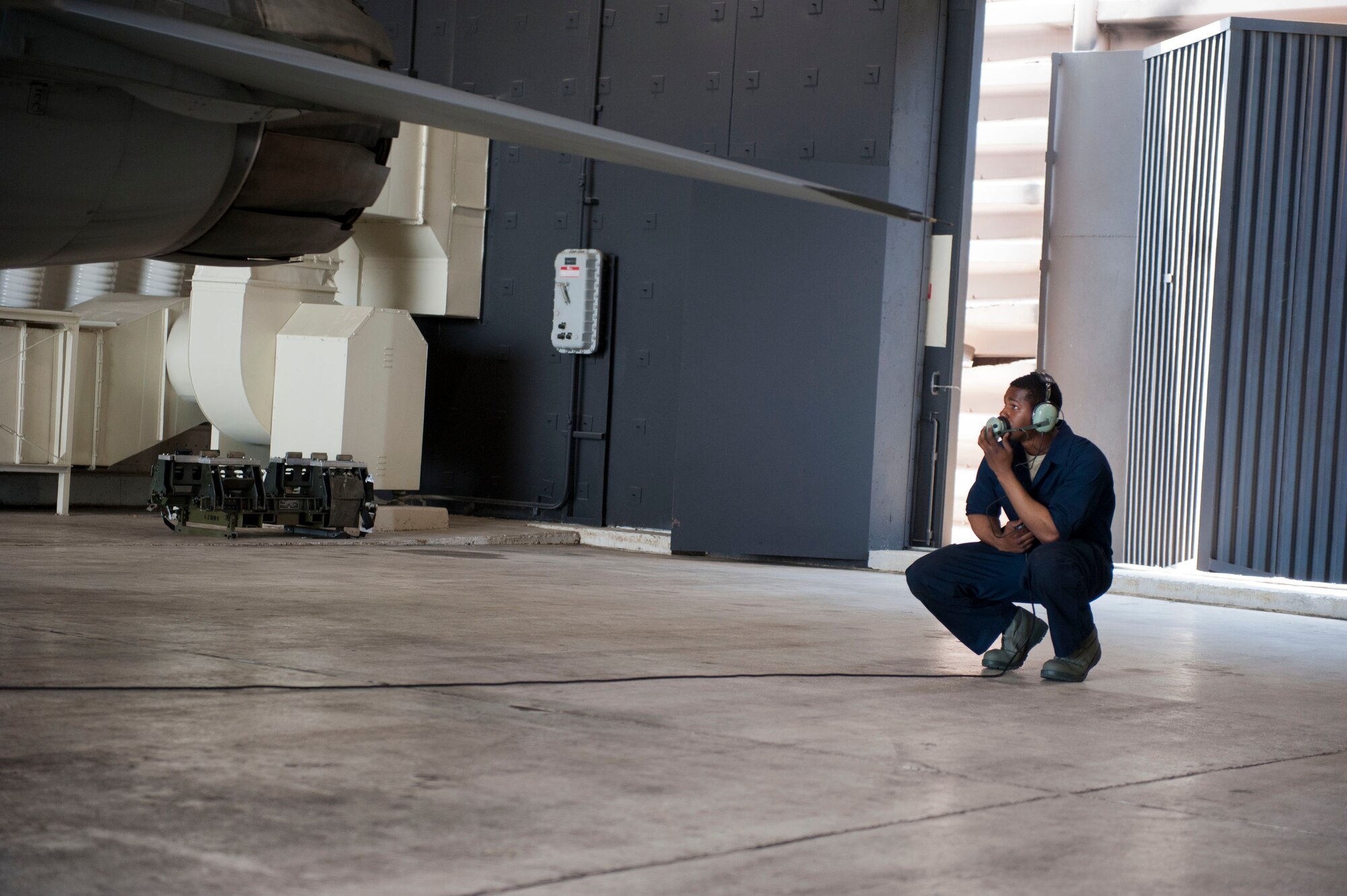 Senior Airman Saeed Oglesby, 8th Aircraft Maintenance Squadron, 80th Aircraft Maintenance Unit assistant dedicated crew chief, communicates with the pilot while conducting checks prior to take off at Kunsan Air Base, Republic of Korea, Apr. 3, 2014. Crew chiefs are responsible for the maintenance and inspection of the aircraft, as well as conducting several overall checks of the aircraft before the pilot arrives for the launch. (U.S. Air Force photo by Staff Sgt. Jessica Haas/Released)