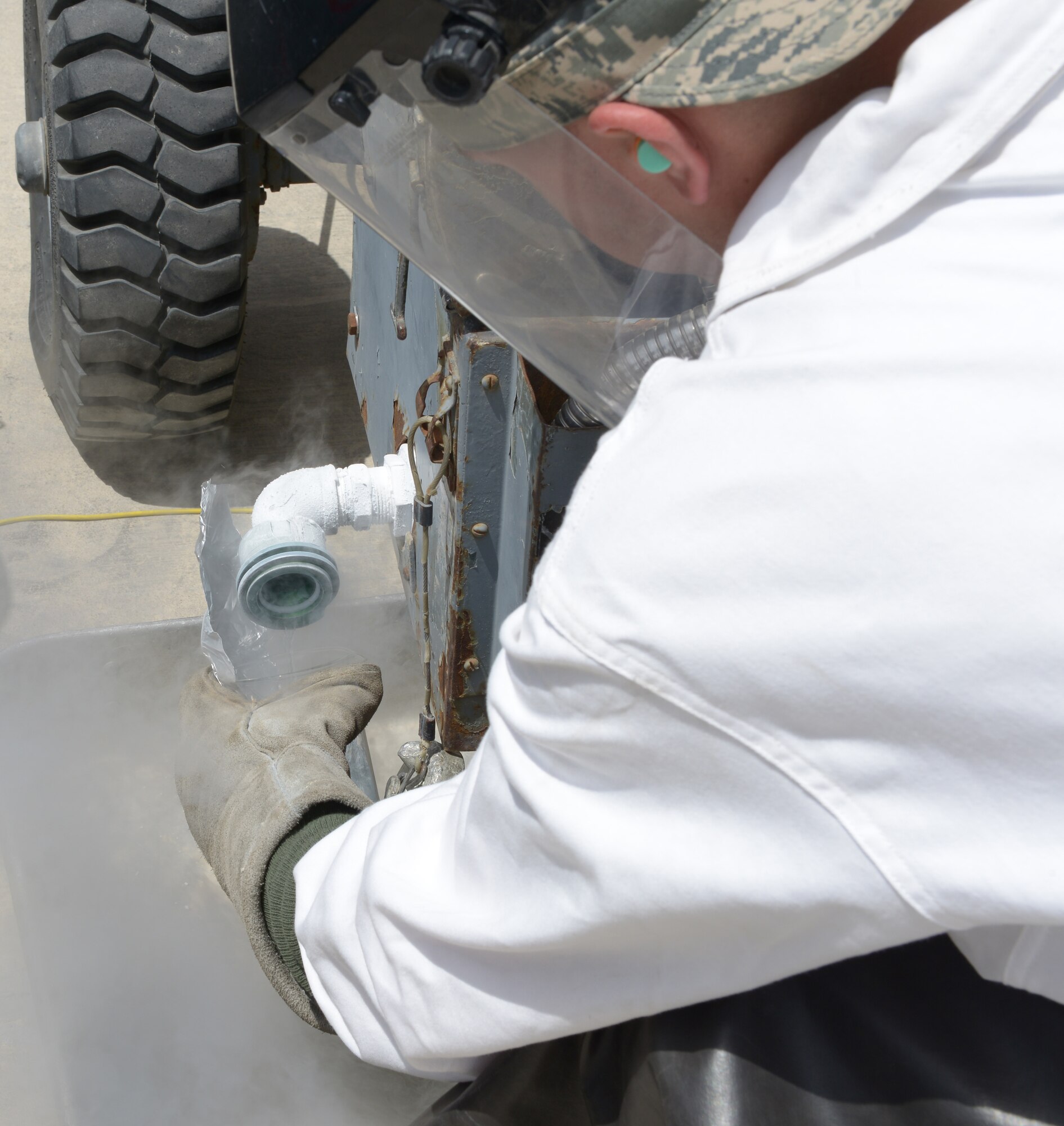 Senior Airman Aaron Megger takes a sample of liquid oxygen at Al Udeid Air Base, Qatar, April 1, 2014. Liquid oxygen is used by aviators, which is needed when reaching high altitudes. Megger is a 379th Expeditionary Logistics Readiness Squadron fuels cryogenic technician, deployed from Joint Base Charleston, S.C., and a Mansfield, Ohio, native. (U.S. Air Force photo/Senior Airman Hannah Landeros)