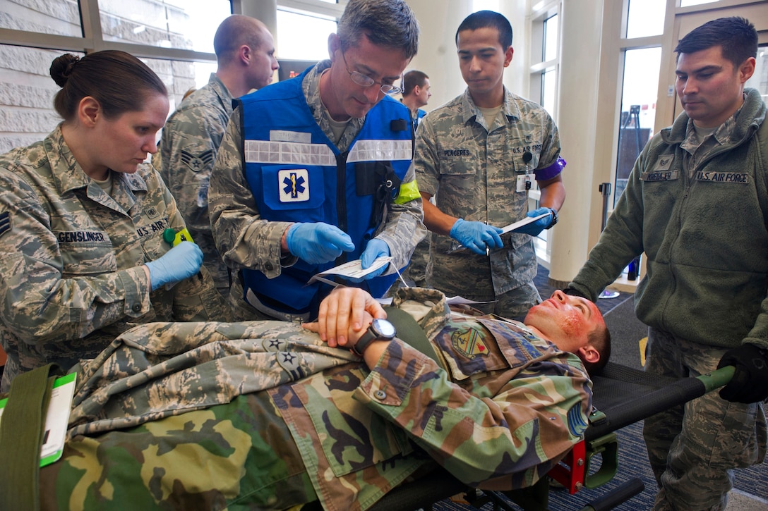 Air Force Lt. Col. (Dr.) Michael Michener, center, evaluates a ...