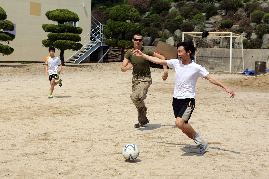 Petty Officer 3rd Class Michael W. Tarnow, a corpsman for the Command Element, 31st Marine Expeditionary Unit, and a native of Boone, Iowa, plays soccer with children from the Pohang orphanage during a visit by 24 Marines and Sailors here, April 5. The Pohang orphanage was founded after the Korean War in 1953 by a Navy chaplain from the 1st Marine Air Wing. In 1954, the Navy Seabees constructed the original building. Since then, the children taken in by the orphanage have known regular visits from their camouflaged friends. The visit comes at the conclusion of the 31st MEU’s participation in Exercise Ssang Yong 2014, a bilateral training event that is a tribute to the maturity of the US-ROK relationship. 