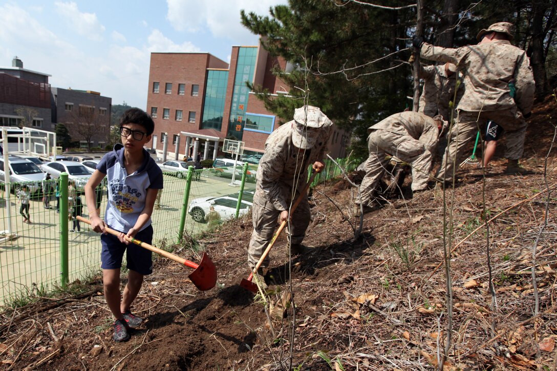 A boy from the Pohang Orphanage helps Marines of the 31st Marine Expeditionary Unit clear land for the planting of rose bushes during a visit here, April 5. The Pohang orphanage was founded after the Korean War in 1953 by a Navy chaplain from the 1st Marine Air Wing. In 1954, the Navy Seabees constructed the original building. Since then, the children taken in by the orphanage have known regular visits from their camouflaged friends. The visit comes at the conclusion of the 31st MEU’s participation in Exercise Ssang Yong 2014, a bilateral training event that is a tribute to the maturity of the US-ROK relationship.  