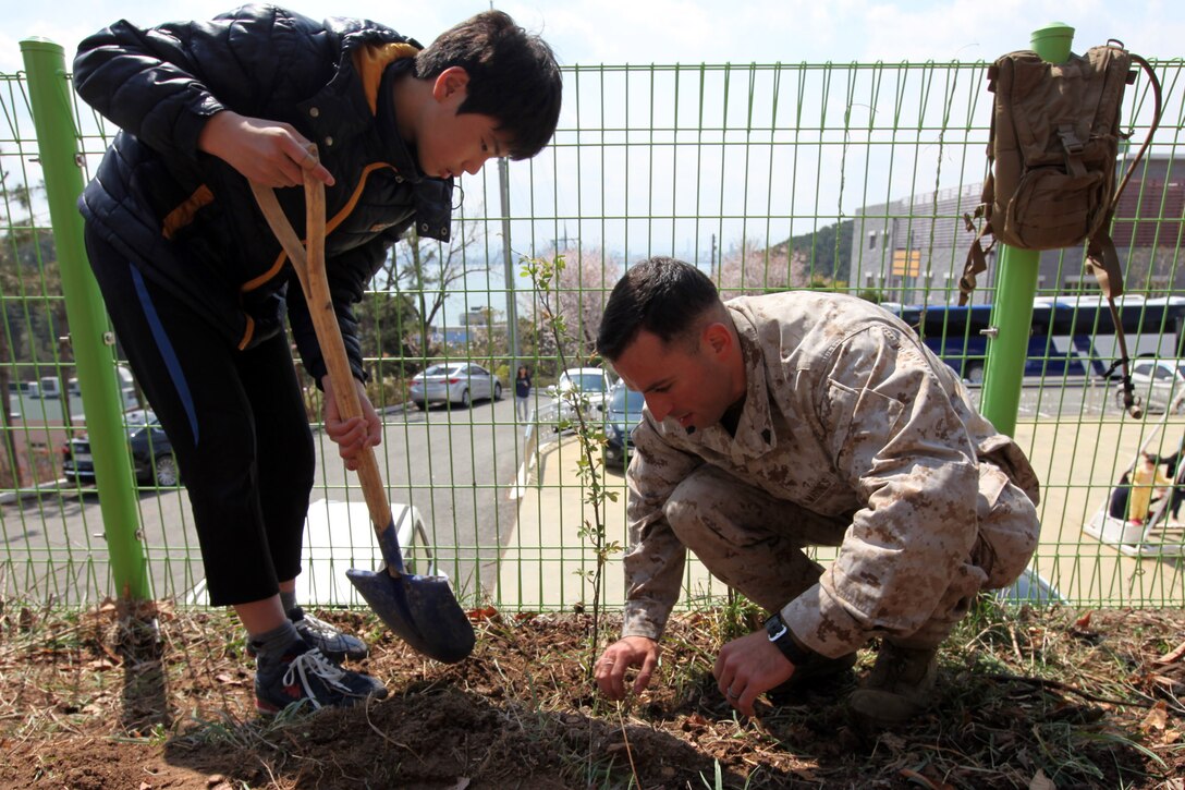 A boy from the Pohang Orphanage helps Sgt. Brendan P. Evans, the staff non-commissioned officer in charge of the air support element, Command Element, 31st Marine Expeditionary Unit, and a native of Oneonta, N.Y., plant a rose bush during a visit by 24 Marines and Sailors here, April 5. The Pohang orphanage was founded after the Korean War in 1953 by a Navy chaplain from the 1st Marine Air Wing. In 1954, the Navy Seabees constructed the original building. Since then, the children taken in by the orphanage have known regular visits from their camouflaged friends. The visit comes at the conclusion of the 31st MEU’s participation in Exercise Ssang Yong 2014, a bilateral training event that is a tribute to the maturity of the US-ROK relationship.  