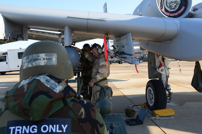 U.S. Air Force Staff Sgt. Ari Rabe, an avionics mechanic assigned to the 175th Aircraft Maintenance Squadron, Maryland Air National Guard, guides a targeting pod (TGP) to an A-10C Thunderbolt under the direction of U.S. Air Force Master Sgt. Andrew Lucas and U.S. Air Force Staff Sgt. Timothy Siders, both avionics specialists assigned to the 175th Aircraft Maintenance Squadron, Maryland Air National Guard, during a Phase II Chemical Warfare Exercise April 5, 2014 at Warfield Air National Guard Base, Baltimore, Md. (U.S. Air National Guard photo by Tech. Sgt. Christopher Schepers)