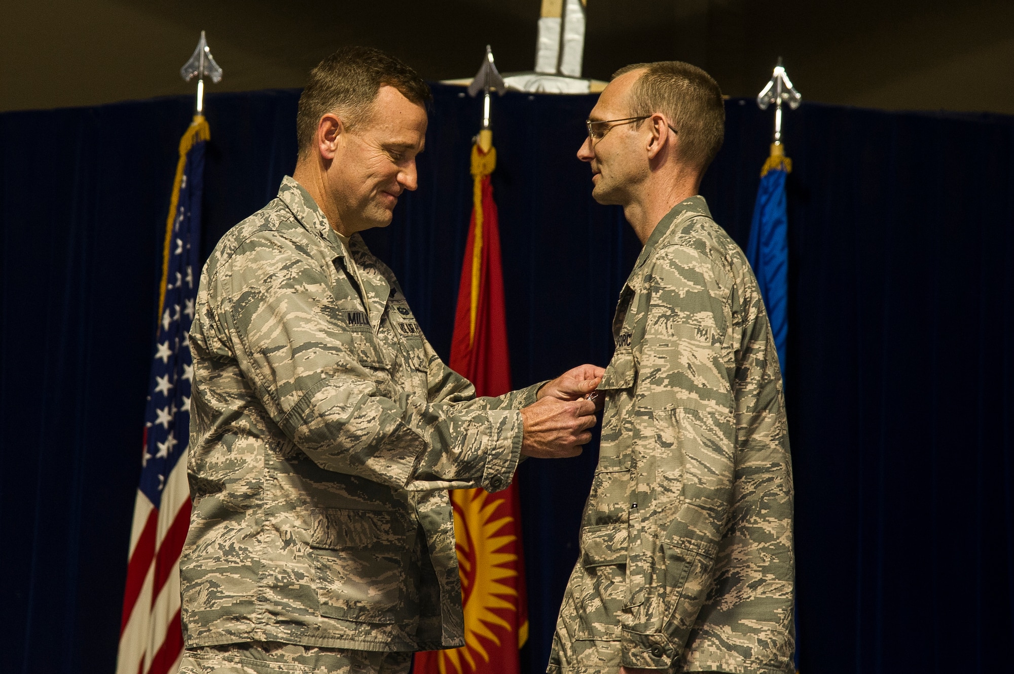 Col. John Millard, 376th Air Expeditionary Wing commander, pins the Bronze Star  medal on Col. James Knowles, 376th Expeditionary Medical Group commander, during the group’s inactivation ceremony at Transit Center at Manas, Kyrgyzstan, April 05, 2014. The 376th EMDG provided routine, urgent and emergency care to anyone who walked through their doors, approximately 14,000 people each year. (U.S. Air Force photo/Senior Airman George Goslin)
