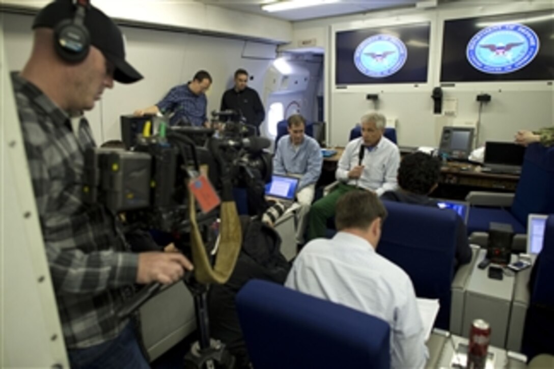 U.S. Defense Secretary Chuck Hagel briefs reporters while en route to Tokyo, April 4, 2014. Hagel was traveling from Honolulu, where he hosted a forum for defense ministers from the Association of South East Asian Nations.