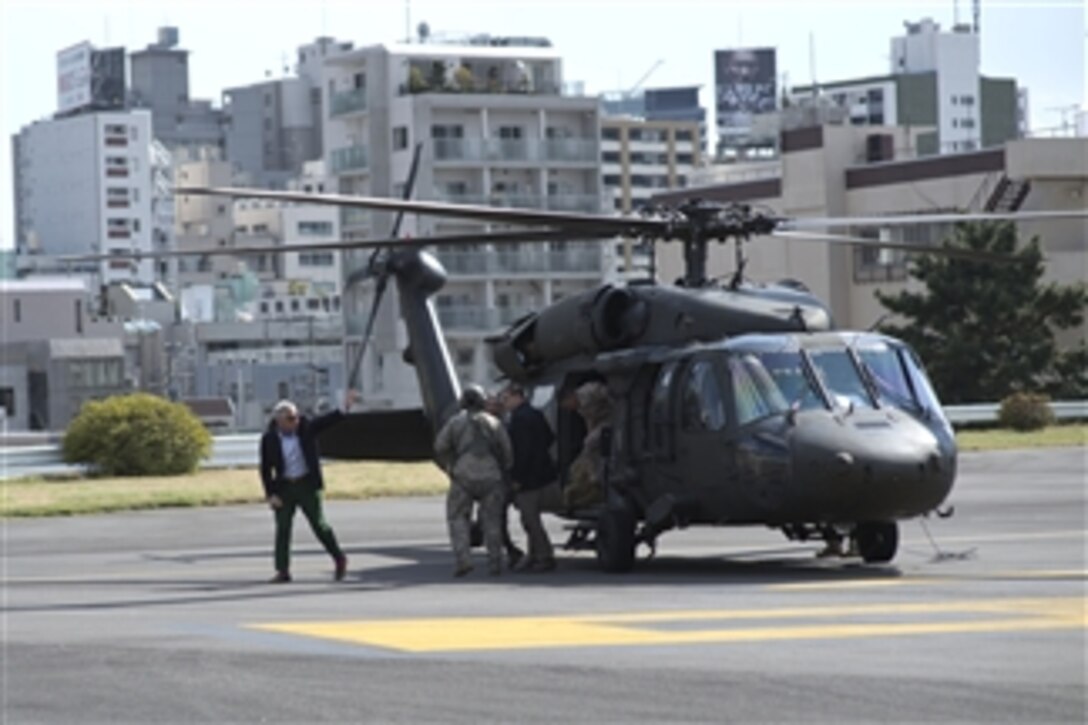 U.S. Defense Secretary Chuck Hagel waves to the pilots of a UH-60 Blackhawk helicopter after landing at Hardy Barracks in Tokyo, April 5, 2014. Hagel met with troops on Yokota Air Force Base earlier in the day and will continue his three-day stay in Tokyo, meeting with the Japanese prime minister and defense and foreign ministers.