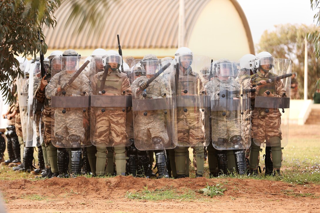 Moroccan soldiers, U.S. Marines with 2nd Law Enforcement Battalion, 2nd Marine Expeditionary Brigade, II Marine Expeditionary Force,  along with Air Force and Army Augments form a unified shield line in response to simulated protesters during a capabilities demonstration for distinguished visitors durin African Lion 2014 in the Tifnit training ara of Morocco Apr 4, 2014.Exercise African Lion 14 is a multi-lateral and combined-joint exercise between the Kingdom of Morocco, the U.S. and other partner nations designed to strengthen relationships with participating countries by increasing understanding of each nation's military capabilities.  The military-to-military portion of the exercise includes: command-post exercises with humanitarian aid and disaster relief themes; stability operations, such as nonlethal weapons training and respond-to-crisis drills; and an intelligence capability-building workshop.