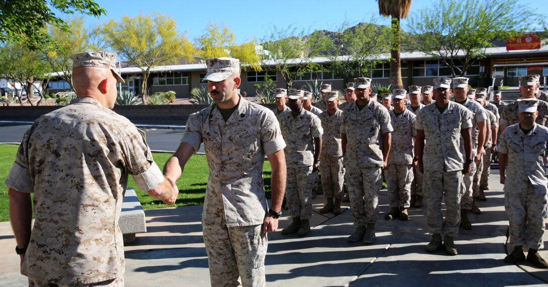 Gunnery Sgt. Craig Wilcox, Company A gunnery sergeant, Headquarters Battalion, shakes hands with Maj. Gen. David H. Berger, Combat Center Commanding General, at the end of his meritorious promotion ceremony at Lance Cpl. Torrey L. Gray Field, April 2, 2014. “He was a stand-out staff sergeant,” said Sgt. Maj. Abel Leal, HQBN sergeant major. “The perception of him is outstanding amongst the senior leaders within HQBN.”(Official Marine Corps Photo By Lance Cpl. Kasey Peacock/Released)