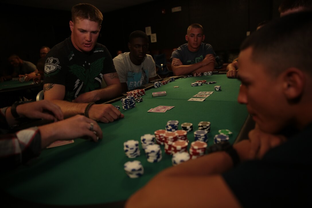 Sgt. John Krumsiek, platoon sergeant, 3rd Battalion, 4th Marines, 7th Marine Regiment, allows another player to cut the deck before he begins dealing the hand during the Texas Hold’em Poker Tournament hosted by the Single Marine Program at The 5th Street Zone, March 28, 2014. Krumsiek was the overall winner of the event and walked away with the prize.


