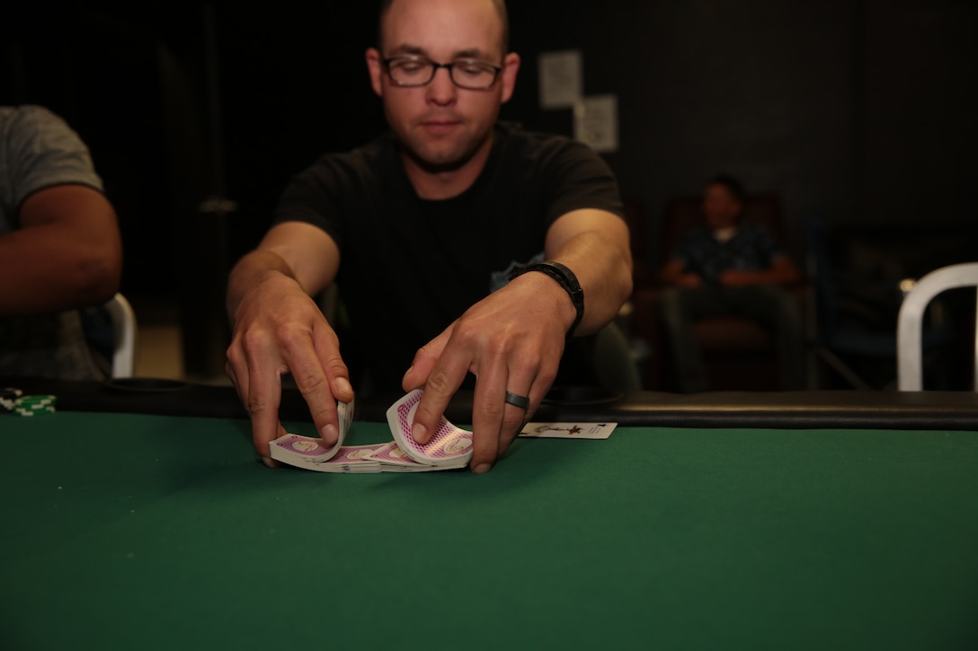 Sgt. Anthony Neal, tow gunner, Tactical Training Exercise Control Group, shuffles a deck of cards before a new hand during the Texas Hold’em Poker Tournament hosted by the Single Marine Program at The 5th Street Zone, March 28, 2014.


