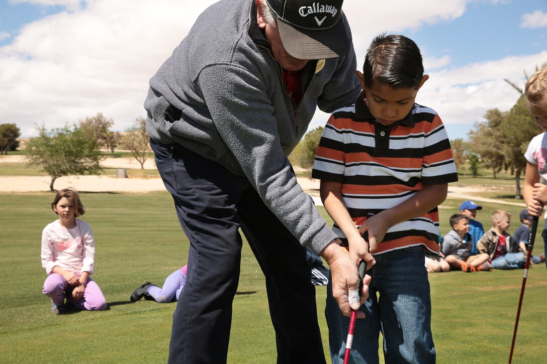 Chuck Mastropaolo, manager, Desert Winds Golf Course, teaches Christopher Perez, 6, son of (Ret.) Gunnery Sgt. Timothy Perez, the proper technique of gripping a golf club during the Homeschool Physical Education Program hosted by Marine Corps Community Services, at Desert Winds Golf Course, April 1, 2014.


