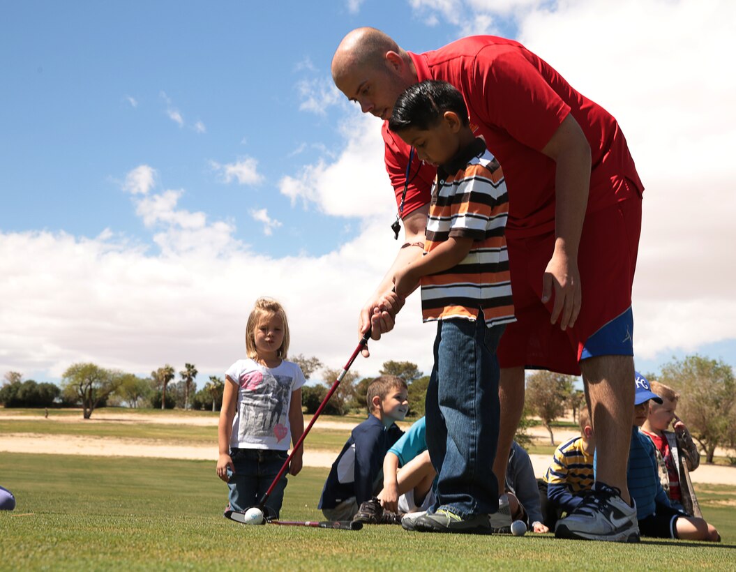 James Burke, director, Youth Sports, Marine Corps Community Services, teaches Christopher Perez, 6, son of (Ret.) Gunnery Sgt. Timothy Perez, about the proper form of a golf swing during the Homeschool Physical Education Program hosted by Marine Corps Community Services, at Desert Winds Golf Course, April 1, 2014.


