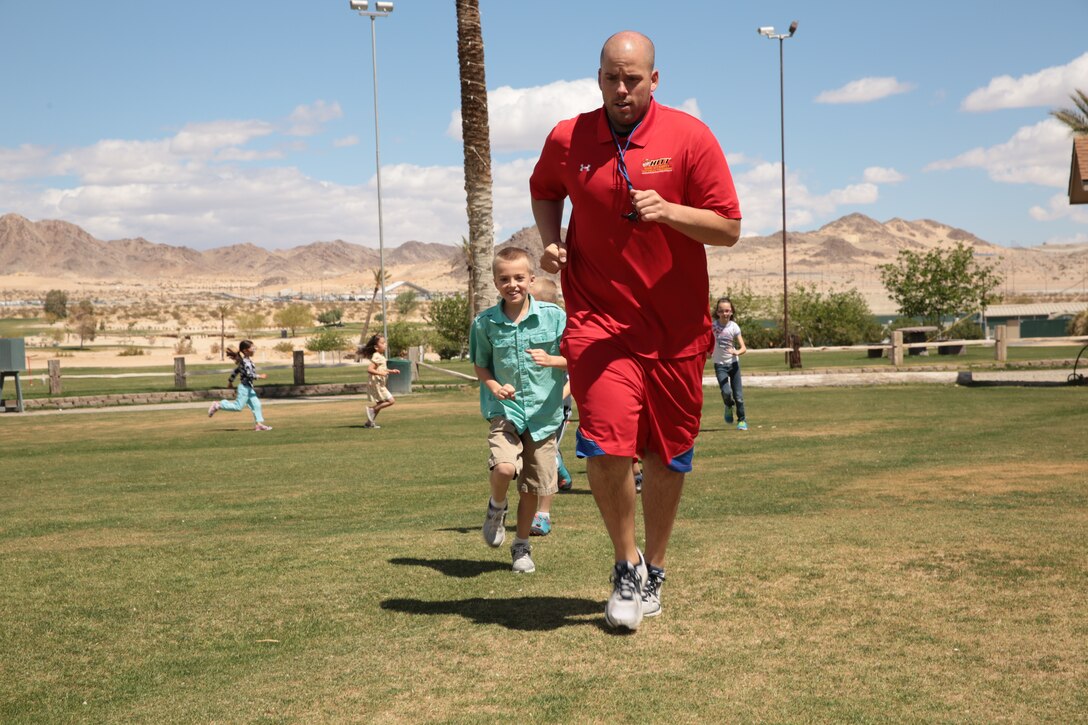 James Burke, director, Youth Sports, Marine Corps Community Services, joins the participants in a warm-up run during the Homeschool Physical Education Program’s weekly class at Desert Winds Golf Course, April 1, 2014. Burke taught golf safety and technique during the class.


