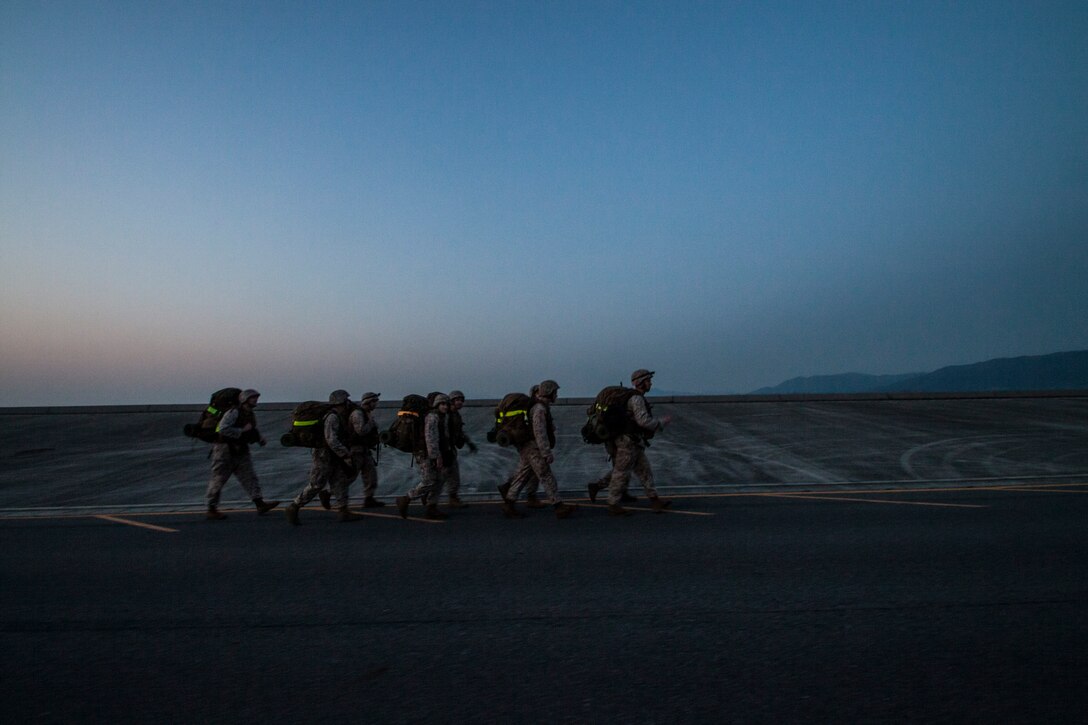 Service members with Headquarters and Headquarters Squadron conduct a hike during a bivouac and hike exercise that took place aboard Marine Corps Air Station Iwakuni, Japan, March 27 - 28, 2014. The evolution gave members of the squadron a chance to practice patrolling techniques, re-familiarize themselves with crew-served weapons and learn call-to-fire procedures. Participants awoke early the day after the bivouac to conduct a 10-kilometer hike in fire teams, ending with a warrior's breakfast at the southside chowhall.