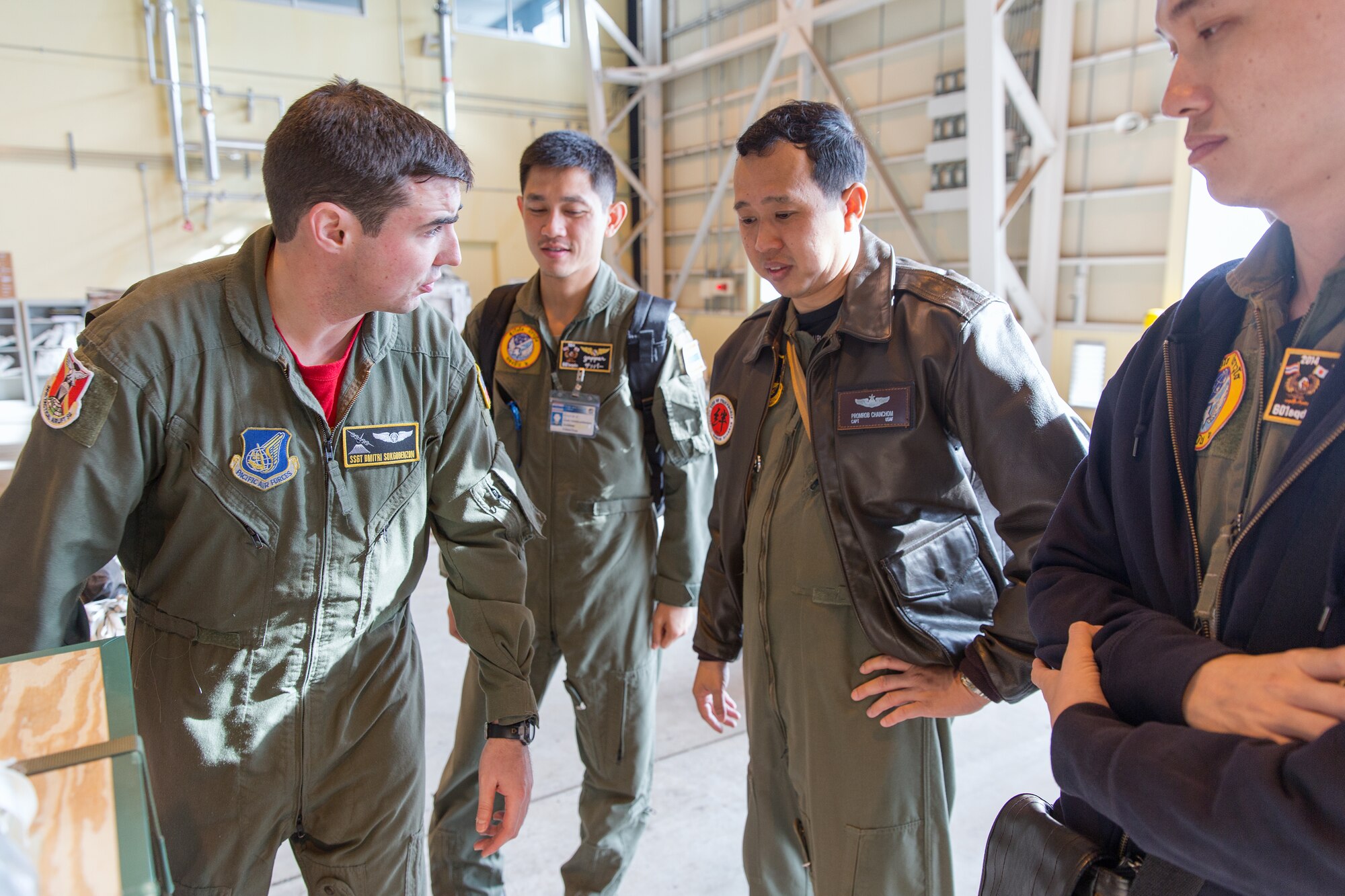 U.S. Air Force Staff Sgt. Dmitri Sokgobenzon (left), 36th Airlift Squadron loadmaster, explains a Low-Cost, Low-Altitude bundle to members from the Royal Thai Air Force in the 374th Combat Mobility Flight at Yokota Air Base, Japan, April 4, 2014. Members of the Royal Thai Air Force visited Yokota for an annual mission of the UNC-R, a tenant unit at Yokota. (U.S. Air Force photo by Osakabe Yasuo/Released)