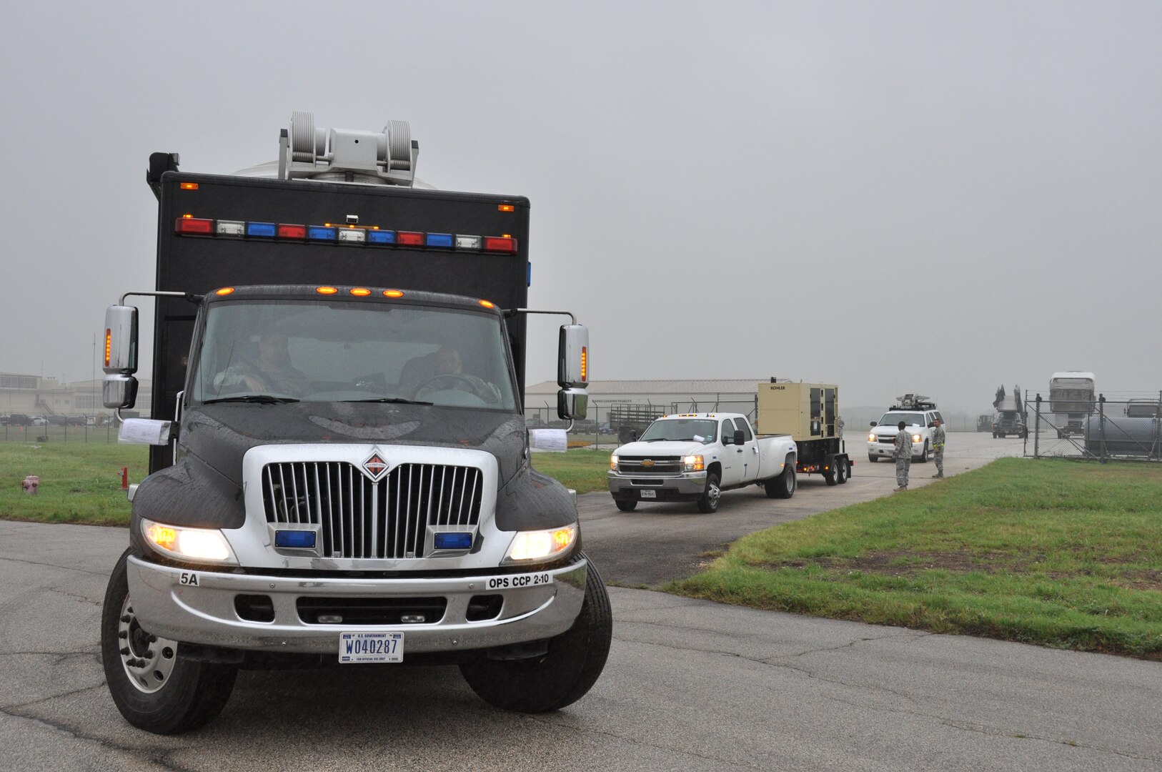 A convoy from Joint Base San Antonio-Ft. Sam Houston’s Army North Task Force-51 departs the Cargo Loading Training Facility at JBSA-Lackland, Texas after being weighed, measured, and inspected by 74th Aerial Port Squadron air transportation special handlers on April 5, 2014. The exercise provided Air Force Reservists and Soldiers an opportunity to on load and offload Task Force-51’s vehicles onto a C-5A Galaxy.   (U.S. Air Force photo by Tech Sgt. Carlos J. Trevino)
