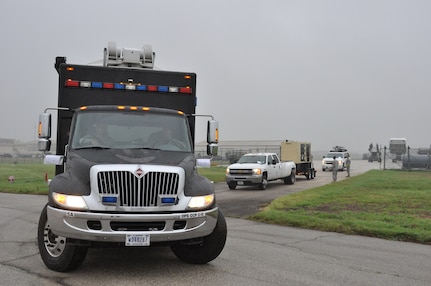 A convoy from Joint Base San Antonio-Ft. Sam Houston’s Army North Task Force-51 departs the Cargo Loading Training Facility at JBSA-Lackland, Texas after being weighed, measured, and inspected by 74th Aerial Port Squadron air transportation special handlers on April 5, 2014. The exercise provided Air Force Reservists and Soldiers an opportunity to on load and offload Task Force-51’s vehicles onto a C-5A Galaxy.   (U.S. Air Force photo by Tech Sgt. Carlos J. Trevino)