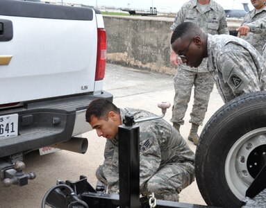 Senior Airman Marcus Alfaro, a 74th Aerial Port Squadron air transportation special handler, prepares to attach a trailer to a truck belonging to Army North’s Task Force-51 on April 5, 2014 at Joint Base San Antonio-Lackland, Texas as Maj. Jamaal A. Mack, a Task Force-51 logistics planner, observes.  Task Force-51, from Joint Base San Antonio-Ft. Sam Houston, Texas, can be employed as an all-hazard task force or a Joint Task Force (JTF) with joint augmentation. (U.S. Air Force photo by Tech Sgt. Carlos J. Trevino)