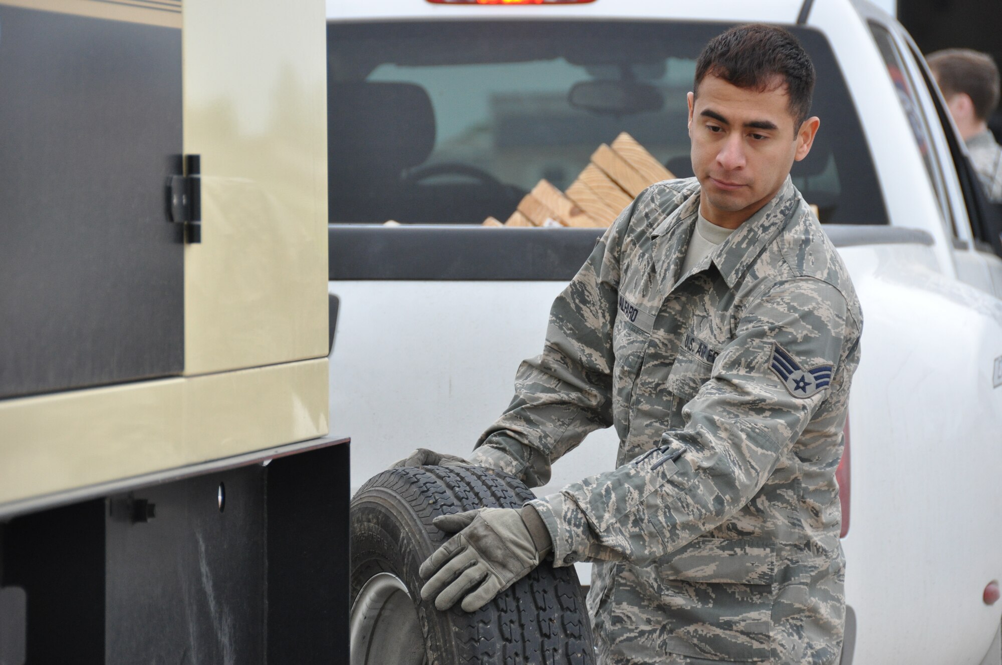 Senior Airman Marcus Alfaro, a 74th Aerial Port Squadron air transportation special handler, relocates a spare tire belonging to a truck from Army North’s Task Force-51, April 5, 2014, at Joint Base San Antonio-Lackland, Texas.  Task Force-51 from Joint Base San Antonio-Ft. Sam Houston, Texas is a full-time deployable command post, who assists local, state and federal responders with disasters in the United States, who have seen catastrophic natural or manmade disasters that exceed their capabilities. (U.S. Air Force photo by Tech Sgt. Carlos J. Trevino)