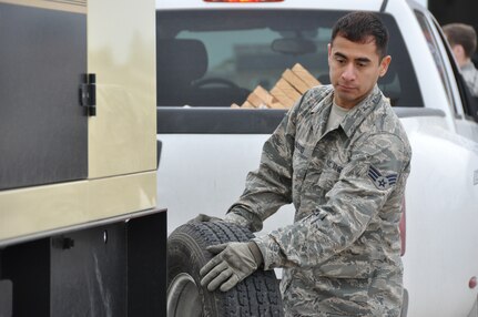 Senior Airman Marcus Alfaro, a 74th Aerial Port Squadron air transportation special handler, relocates a spare tire belonging to a truck from Army North’s Task Force-51, April 5, 2014, at Joint Base San Antonio-Lackland, Texas.  Task Force-51 from Joint Base San Antonio-Ft. Sam Houston, Texas is a full-time deployable command post, who assists local, state and federal responders with disasters in the United States, who have seen catastrophic natural or manmade disasters that exceed their capabilities. (U.S. Air Force photo by Tech Sgt. Carlos J. Trevino)