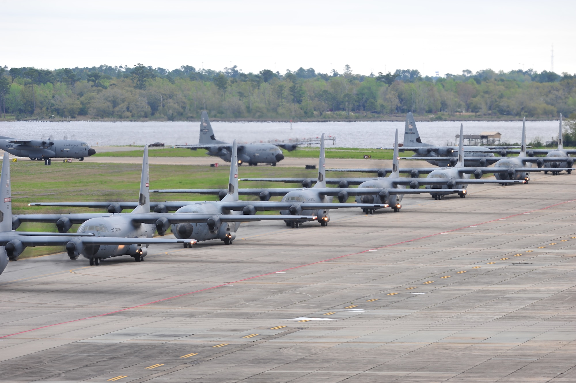A line of C-130J aircraft from the 815th and 345th and WC-130J aircraft from the 53rd Weather Reconnaissance Squadron taxi onto the runway before takeoff for Operation Surge Capacity here April, 5, 2014.  Sixteen aircraft from the 403rd Wing took part in a large scale training exercise designed to test the wing's abiltiy to launch and recover a large formation of aircraft and to execute airdrops.  (U.S. Air Force photo/Tech. Sgt. Ryan Labadens)