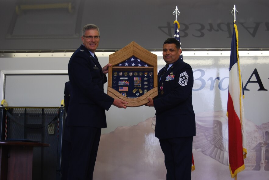 Command Chief Master. Sgt. Emil Garza, 433rd Airlift Wing, receives a shadow box from Col. Aaron Vangelisti, commander, 433 AW at his retirement ceremony at Joint Base San Antonio-Lackland, April 5, 2014.  (U.S. Air Force photo by Capt. Philip Cortez/Released)