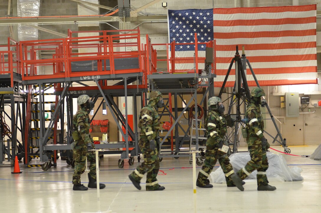 U.S. Air Force Airmen walk through a simulated attack scene during an Ability to Survive and Operate (ATSO) exercise at Rosecrans Air National Guard Base, Mo., Apr. 4, 2014.  The ATSO exercise gave Airmen the opportunity to practice how to correctly don their protective uniform, describe an attack scene to authorities, and move from a contaminated zone to a clean zone. (U.S. Air National Guard photo by Tech. Sgt. Theo Ramsey/Released)