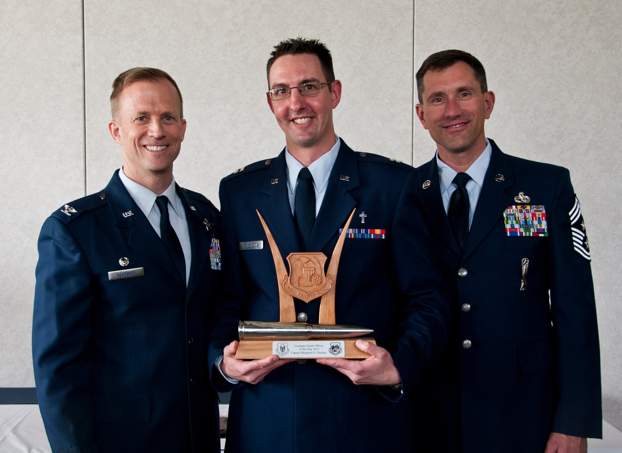 U.S. Air Force Col. Hubie Hegtvedt, 442nd Fighter Wing commander, and Chief Master Sgt. James Nudd, 442nd FW command chief, pose with Chaplain (Capt.) Benjamin Hayden, 442nd FW chaplain, at the 442 FW annual awards luncheon at the Whiteman Air Force Base, Mo. Royal Oaks golf course April 6, 2014. Hayden was awarded Company Grade Officer of the Year for 2013 at the awards ceremony. (U.S. Air Force photo by Senior Airman Daniel Phelps/Released)