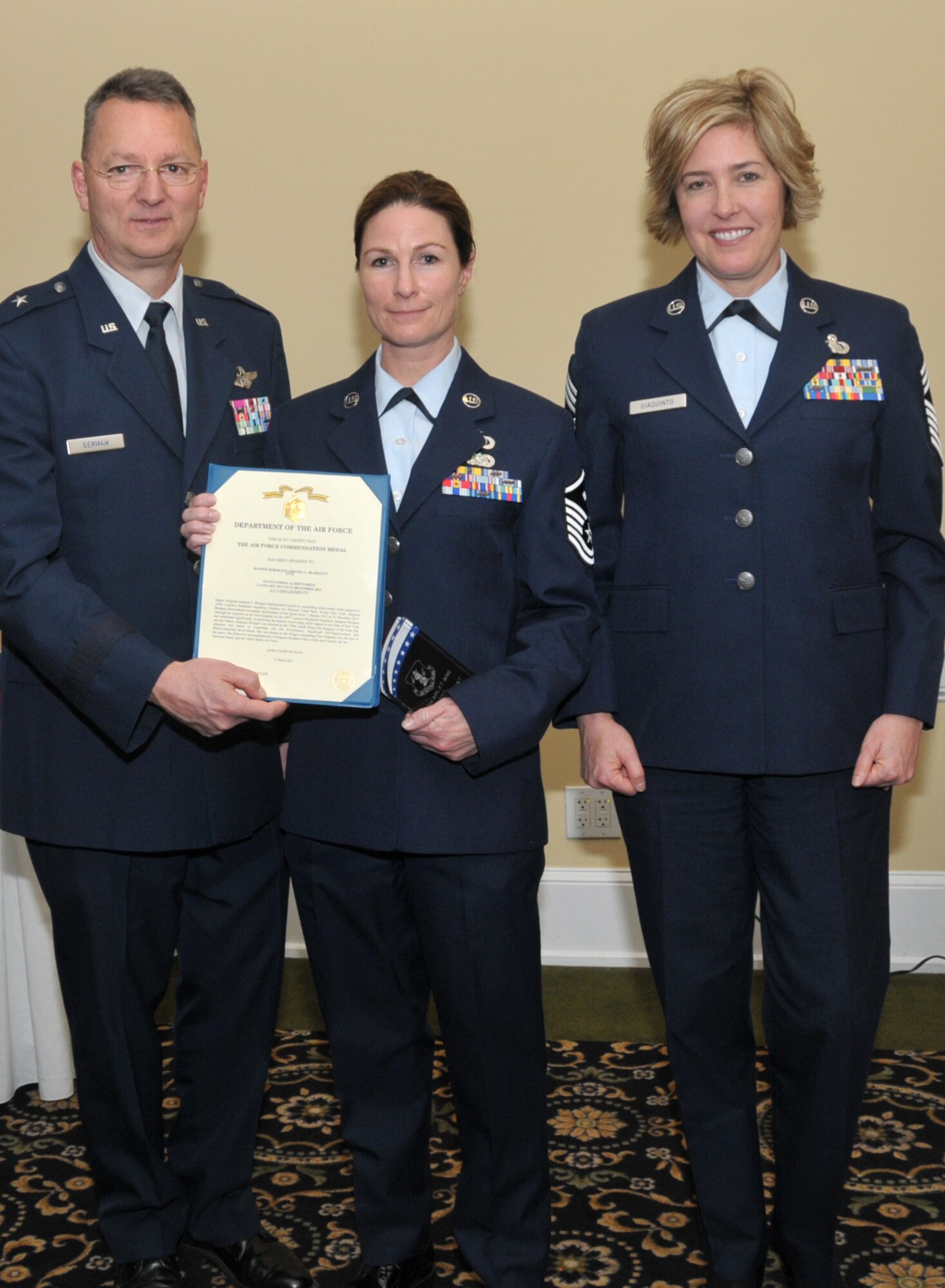 SCOTIA, N.Y. -- Master Sgt. Amanda Blodgett, center, was named the 109th Airlift Wing's First Sergeant of the Year. She was honored during the annual Airman of the Year Dinner on April 5. Also pictured are Brig. Gen. Anthony German, New York's Chief of Staff-Air, and Chief Master Sgt. Amy Giaquinto, 109th AW command chief.  Blodgett is assigned to the 109th Logistics Readiness Squadron. (Air National Guard photo by Master Sgt. William Gizara/Released)