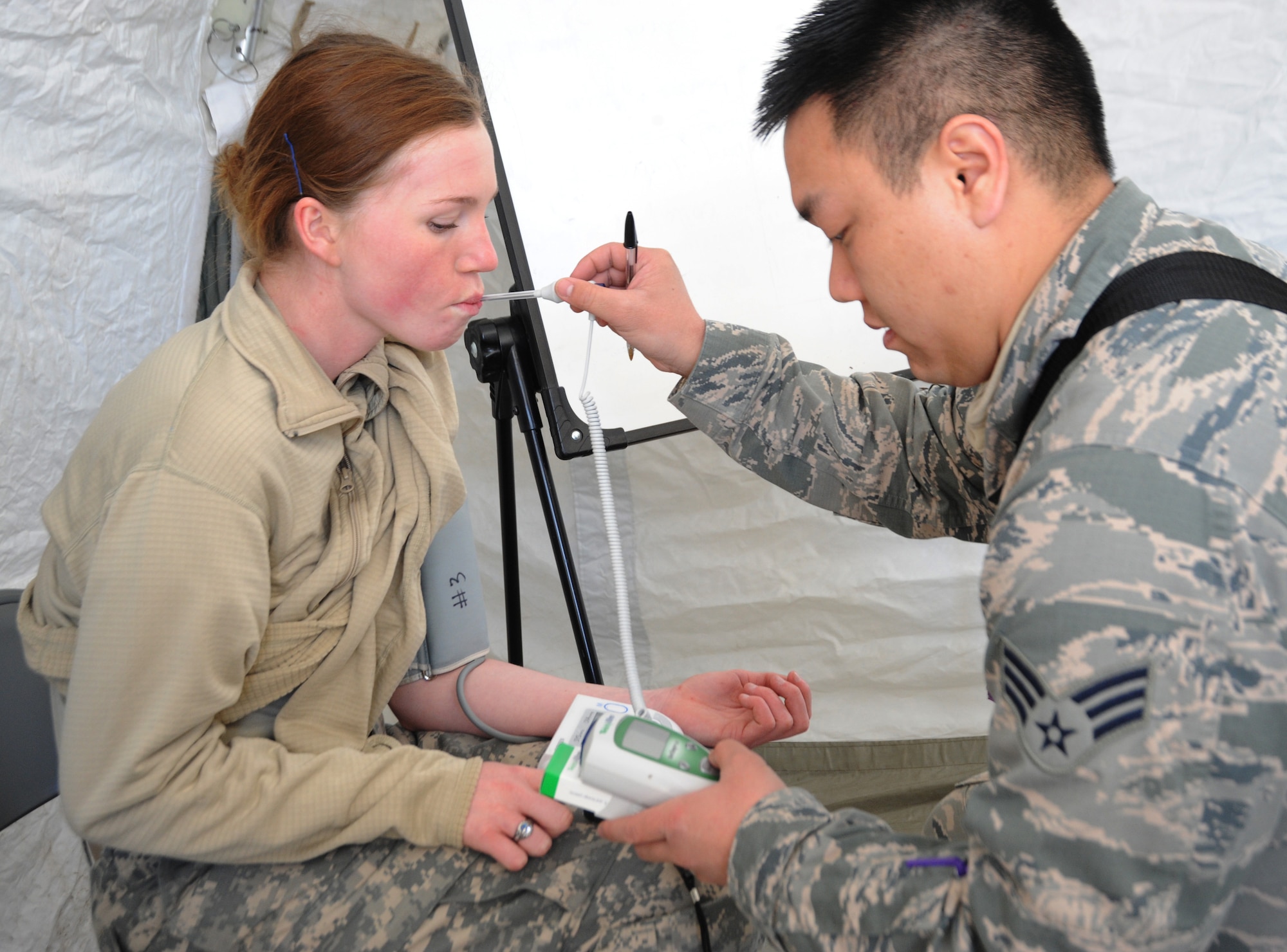 Air National Guard Senior Airman Charlie Phu takes vital readings from Army National Guard Pfc. Jessica Lammert after she has finished her shift in the decontamination process of victims in the Vigilant Guard-Alaska 2014 exercise, near Joint Base Elmendorf-Richardson, Anchorage, Alaska, March 28, 2014. Both are members of the Oregon National Guard’s CBRNE Enhanced Response Force Package (CERFP). (U.S. Air National Guard photo by Tech. Sgt. John Hughel, 142nd Fighter Wing Public Affairs/Released)