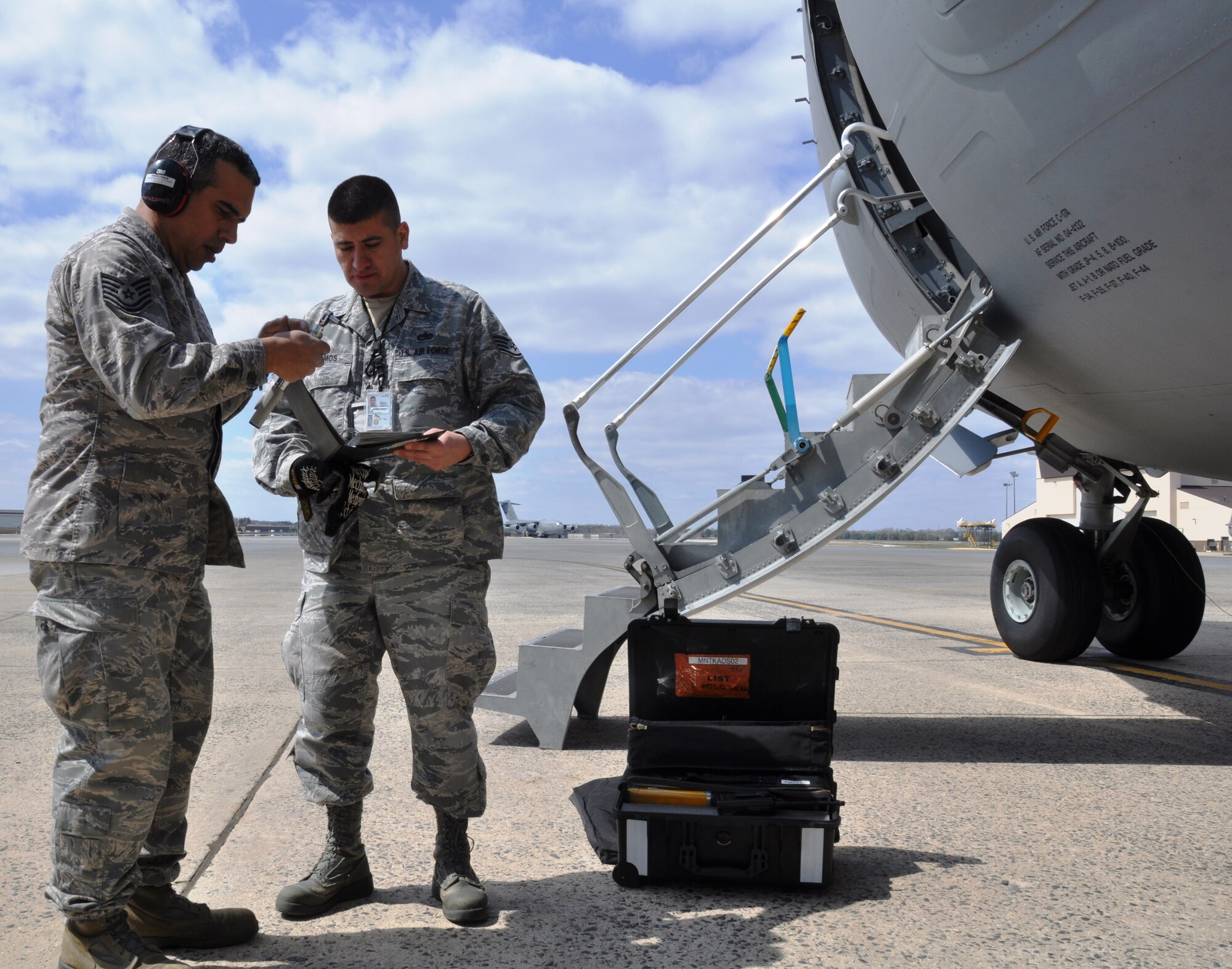 Tech Sgt. Dionisio Velez and Staff Sgt. Michael Ramos, 514th Aircraft Maintenance Squadron electronic warfare systems technicians, review a flare checklist while performing maintenance a C-17 Globemaster III aircraft here April 5 (U.S. Air Force photo Senior Airman Chelsea Smith).