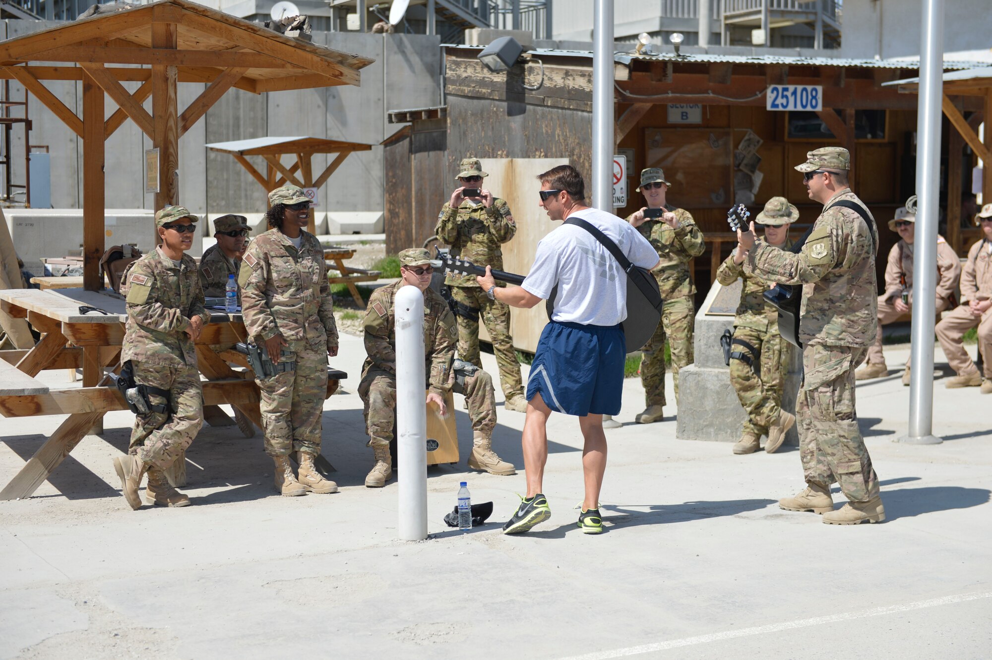 U.S. Air Force Maj. Sonny Millonzi, a C-17 pilot deployed from the Channel Islands Air National Guard base, joins in with the U.S. Air Force Central Command Band, Hyper Sonic, as they played a street performance at Bagram Airfield, Afghanistan, March 31, 2014. Bagram was one stop on Hyper Sonic’s Afghanistan tour.(U.S. Air Force photo by Senior Master Sgt. Gary J. Rihn/Released) 