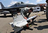 Senior Airman Phillip Meyer, 421st Aircraft Maintenance Unit weapons load crew member, inspects a missile during a quarterly weapons load crew competition at Osan Air Base, Republic of Korea, April 4, 2014. Load crew competitions are held to give weapons personnel the opportunity to display their war-fighting skills and to unveil the best weapons load crew for a particular quarter during the year. (U.S. Air Force photo/Senior Airman Siuta B. Ika)