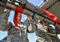 Weapons load crew members from the 25th Aircraft Maintenance Unit place a missile on their team’s A-10 Thunderbolt II during a quarterly weapons load crew competition at Osan Air Base, Republic of Korea, April 4, 2014. In order for the load crews to earn their place in the competition, they must prove themselves during their monthly proficiency loads, quarterly evaluations, and every-day mission. (U.S. Air Force photo/Senior Airman Siuta B. Ika)