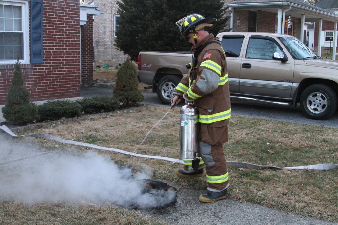 Gunnery Sgt. Travis Albrecht, the logistics chief for 4th Marine Corps District and native of LaMarque, Texas, uses a fire extinguisher to put out part of a chimney fire in Camp Hill, Pa., March 24, 2014.  Along with being a Marine, Albrecht has been a volunteer at the Camp Hill Fire Department for four months.   (U.S. Marine Corps photo by Lance Cpl Kyle R. Welshans/Released) 